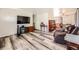 Bright living room featuring wood-look floors, a modern television, and open floor plan at 2986 W Union Ave, Englewood, CO 80110