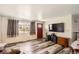 Bright living room featuring wood-look floors, a modern television, and ample natural light at 2986 W Union Ave, Englewood, CO 80110