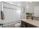 Cozy bathroom featuring a shower with a stylish curtain, a vanity with storage, and neutral decor at 15773 Timber Trek Way, Monument, CO 80132