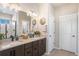 Elegant bathroom with double sinks, modern lighting, and sleek cabinetry, with a neutral color palette at 15773 Timber Trek Way, Monument, CO 80132