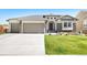 Inviting home featuring a manicured lawn, stone accents, arched entrance, and a spacious three-car garage at 15773 Timber Trek Way, Monument, CO 80132