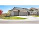 A modern home featuring a three-car garage, stone accents, manicured lawn, and landscaped surroundings at 15773 Timber Trek Way, Monument, CO 80132