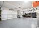 Spacious three-car garage with epoxy flooring, storage shelves, and room for vehicles, bikes, and gear at 15773 Timber Trek Way, Monument, CO 80132