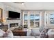 Stylish living room with modern fireplace, mounted TV, hardwood floors, and a view of mountains from sliding glass doors at 15773 Timber Trek Way, Monument, CO 80132