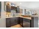 Stylish wet bar featuring modern cabinetry, tiled backsplash, and sleek countertops at 15773 Timber Trek Way, Monument, CO 80132