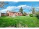 Spacious backyard with a brick home, featuring a wooden deck and plenty of green space at 12030 W Alameda Pkwy, Lakewood, CO 80228