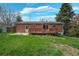 Inviting backyard with brick home, wood deck, and green lawn perfect for outdoor enjoyment at 12030 W Alameda Pkwy, Lakewood, CO 80228