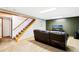 Finished basement with a comfortable brown leather sofa and carpet floors at 12030 W Alameda Pkwy, Lakewood, CO 80228
