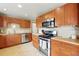 Well-equipped kitchen with wood cabinets, stainless steel appliances, and stylish backsplash, offering ample counter space at 12030 W Alameda Pkwy, Lakewood, CO 80228