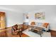 Open living room features hardwood floors, light gray sofa, and minimalist decor, creating a clean and modern space at 12030 W Alameda Pkwy, Lakewood, CO 80228