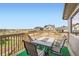 Back deck featuring an outdoor dining set, green turf and neighborhood views at 26731 E Hinsdale Pl, Aurora, CO 80016