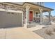 Close up of a two-story home featuring stone accents, and covered porch with a red front door at 26731 E Hinsdale Pl, Aurora, CO 80016