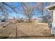 Large, partially fenced backyard featuring a detached garage with a small concrete driveway leading to the street at 901 S Osceola St, Denver, CO 80219