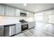 Open kitchen featuring stainless steel appliances, light gray cabinets, and laminate flooring at 901 S Osceola St, Denver, CO 80219