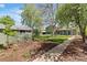 Landscaped backyard featuring mature trees, shed, and sidewalk leading to the home at 845 S Kenton St, Aurora, CO 80012