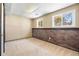 Finished basement with carpet flooring, brick accents, and two bright windows at 845 S Kenton St, Aurora, CO 80012