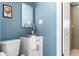 Charming powder room featuring blue walls, updated vanity and stainless steel faucet at 845 S Kenton St, Aurora, CO 80012