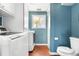 Bathroom with a laundry machine and dryer, a toilet, and a window with a palm tree at 845 S Kenton St, Aurora, CO 80012