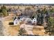 Aerial view of white house with circular drive surrounded by tall trees at 1 Random Rd, Englewood, CO 80113