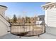 This balcony has black metal railings and a view of a spacious lawn with mature trees and a house at 1 Random Rd, Englewood, CO 80113