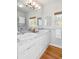 Bathroom featuring double sinks with vanity and two large mirrors, and wood accents at 1 Random Rd, Englewood, CO 80113