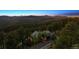 Scenic aerial view of a home nestled in the mountains, surrounded by lush forests and a winding driveway at 26116 Chief Hosa Rd, Golden, CO 80401