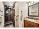 Bathroom featuring a walk-in glass shower, granite counters, and wooden cabinets at 26116 Chief Hosa Rd, Golden, CO 80401