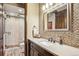 Modern bathroom featuring tiled accent wall, sleek vanity, and glass-enclosed shower at 26116 Chief Hosa Rd, Golden, CO 80401