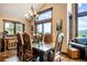 Elegant dining room featuring a large wooden table and chairs, chandelier, and expansive windows with mountain views at 26116 Chief Hosa Rd, Golden, CO 80401
