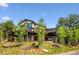 Beautiful two-story home with a large deck, stone accents, and mature trees enhancing the landscape at 26116 Chief Hosa Rd, Golden, CO 80401