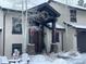 Charming home exterior featuring a snow-covered yard and a festive holiday wreath on the front door at 26116 Chief Hosa Rd, Golden, CO 80401