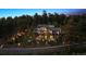 Picturesque home exterior surrounded by mature trees and landscaped grounds at dusk at 26116 Chief Hosa Rd, Golden, CO 80401