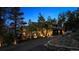 Elegant home exterior at twilight with a stone driveway, mature trees, and manicured landscaping at 26116 Chief Hosa Rd, Golden, CO 80401