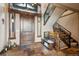Elegant foyer with slate flooring, a wooden staircase, and a stylish bench creating a welcoming entrance at 26116 Chief Hosa Rd, Golden, CO 80401