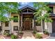 Inviting front entrance featuring a stone walkway, wooden door, and decorative flower baskets at 26116 Chief Hosa Rd, Golden, CO 80401