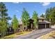 Stunning home with a spacious driveway, beautiful trees, and a deck overlooking a serene landscape at 26116 Chief Hosa Rd, Golden, CO 80401