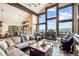 Spacious living room with high ceilings, stone fireplace, large windows, and scenic views at 26116 Chief Hosa Rd, Golden, CO 80401