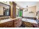 Stylish main bathroom featuring double vanities, soaking tub with stone accents, and modern fixtures at 26116 Chief Hosa Rd, Golden, CO 80401