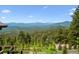 Breathtaking mountain views surrounded by lush trees from the deck at 26116 Chief Hosa Rd, Golden, CO 80401