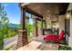 Expansive covered patio featuring stone columns, lounge chairs, and scenic views at 26116 Chief Hosa Rd, Golden, CO 80401