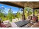 Covered patio with beautiful views, comfortable seating, and stylish outdoor furniture at 26116 Chief Hosa Rd, Golden, CO 80401