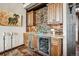 Charming wet bar area showcasing stone accents, wooden cabinets, granite countertops, and stainless steel wine cooler at 26116 Chief Hosa Rd, Golden, CO 80401