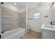 Bright bathroom featuring a bathtub with stylish tile surround and modern fixtures at 691 N Tempe St, Aurora, CO 80018