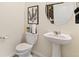 Half bath with a pedestal sink, toilet, and modern decor at 691 N Tempe St, Aurora, CO 80018