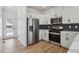 Modern kitchen features white cabinets, stainless steel appliances, and stylish backsplash at 691 N Tempe St, Aurora, CO 80018