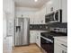 Well-equipped kitchen features stainless steel appliances, bright white cabinets, and tile backsplash at 691 N Tempe St, Aurora, CO 80018