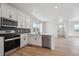 Open kitchen with white cabinets, stainless appliances, and modern fixtures at 691 N Tempe St, Aurora, CO 80018