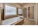 Bright bathroom featuring a soaking tub, a glass-enclosed shower, and tiled floor at 9040 Grand Mesa Ave, Longmont, CO 80504