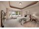 Spacious bedroom with a tray ceiling, large windows and a cozy seating area at 9040 Grand Mesa Ave, Longmont, CO 80504