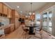 Open kitchen and dining area with light wood cabinets, stainless appliances, and a sliding glass door at 9040 Grand Mesa Ave, Longmont, CO 80504
